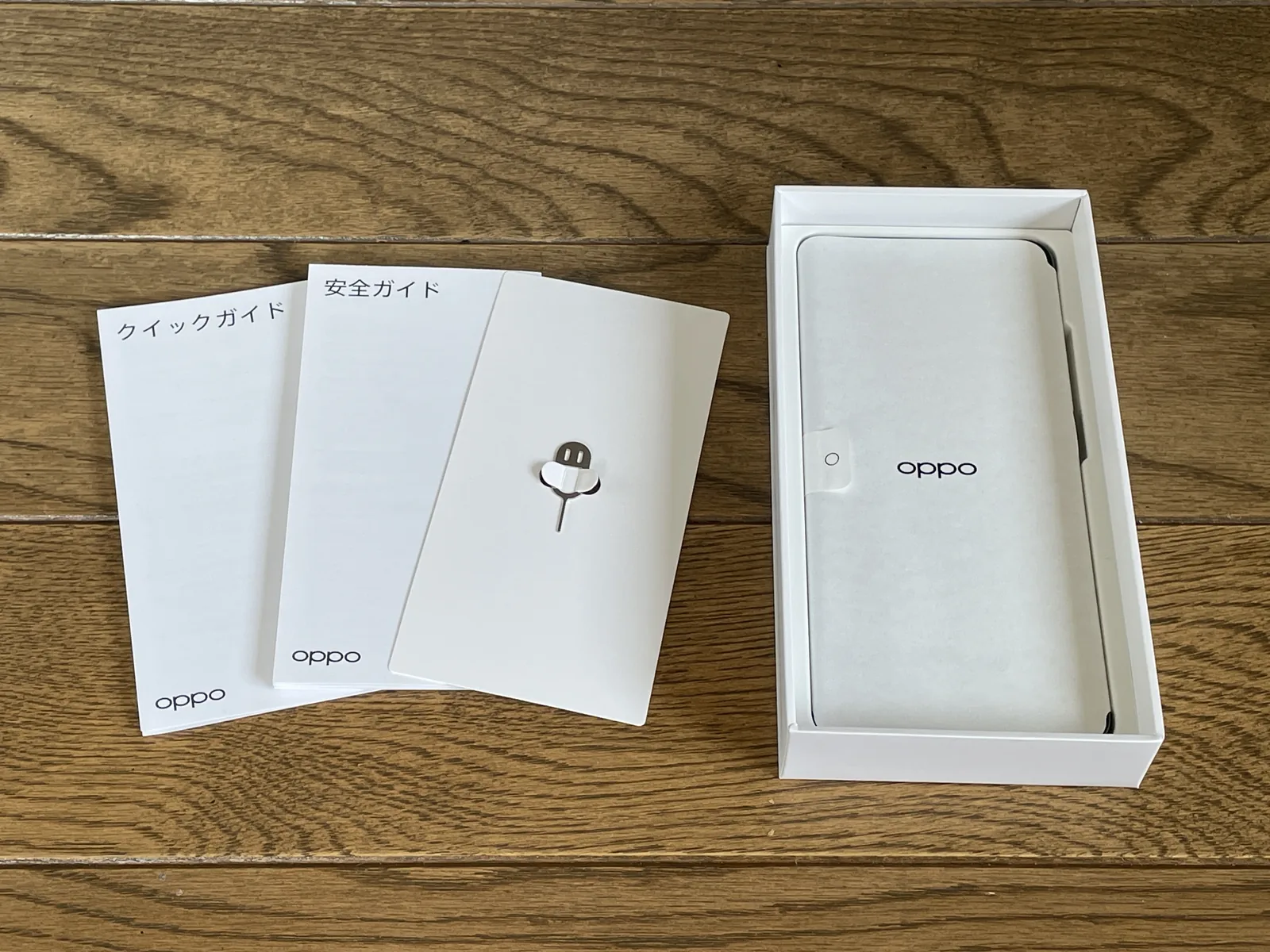 OPPO A5 5Gの付属品であるクイックガイド、安全ガイド、SIMピンとスマートフォン本体