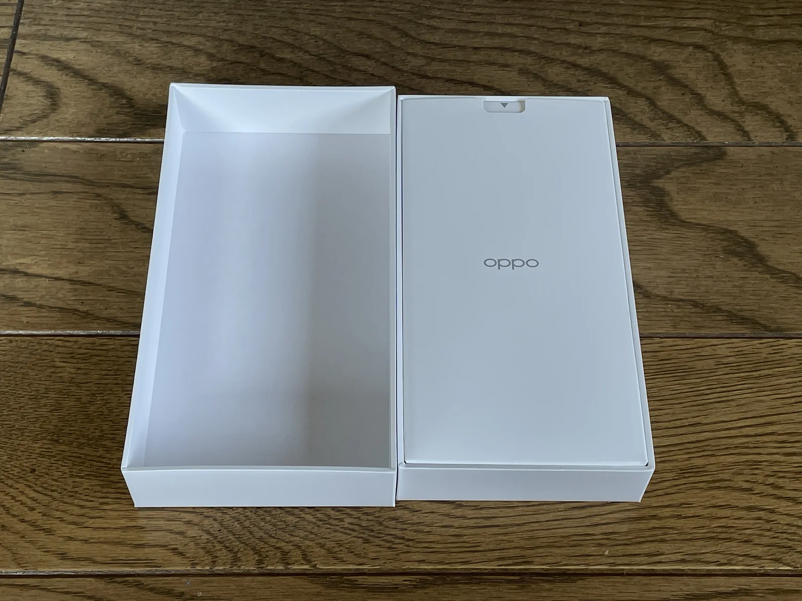OPPO A5 5Gの製品箱を開封し、OPPOロゴ入りの付属品ケースを確認している様子