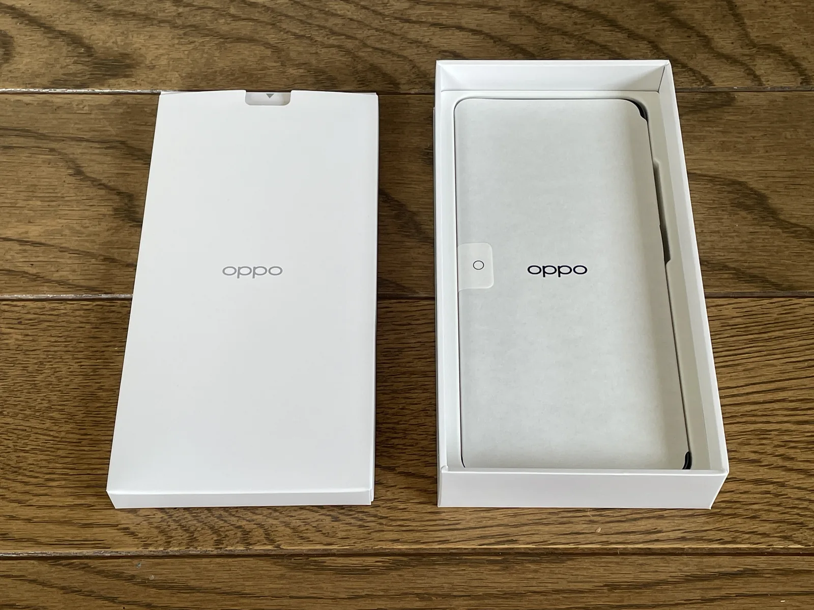 OPPO A5 5Gを開封し、製品箱の中に保護紙で包まれたスマートフォン本体が入っている状態