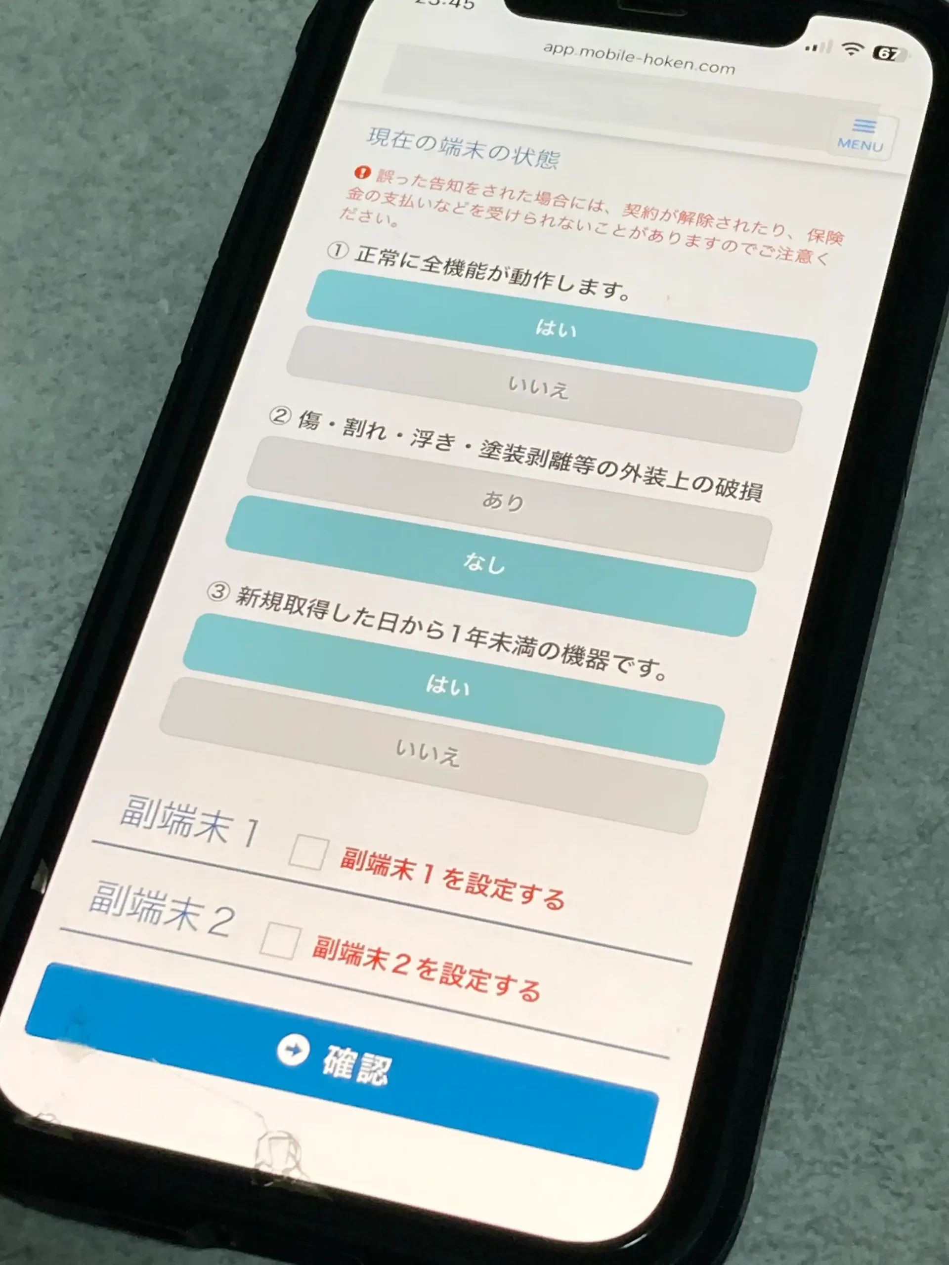 モバイル保険の登録端末の現在の状態を答える告知の質問と、副端末を設定する欄をスマホで撮影した写真