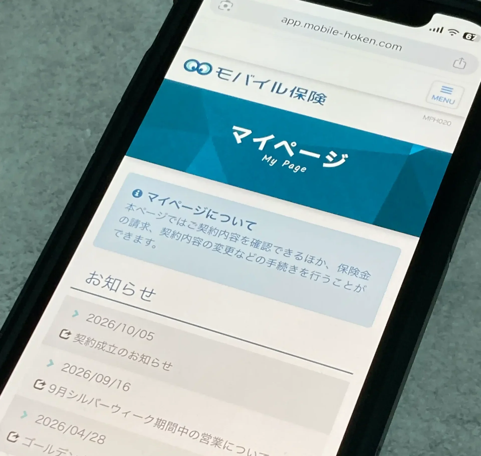 モバイル保険のマイページのトップ画面。お知らせ欄に契約成立のお知らせが出ている様子をスマホで撮影した写真