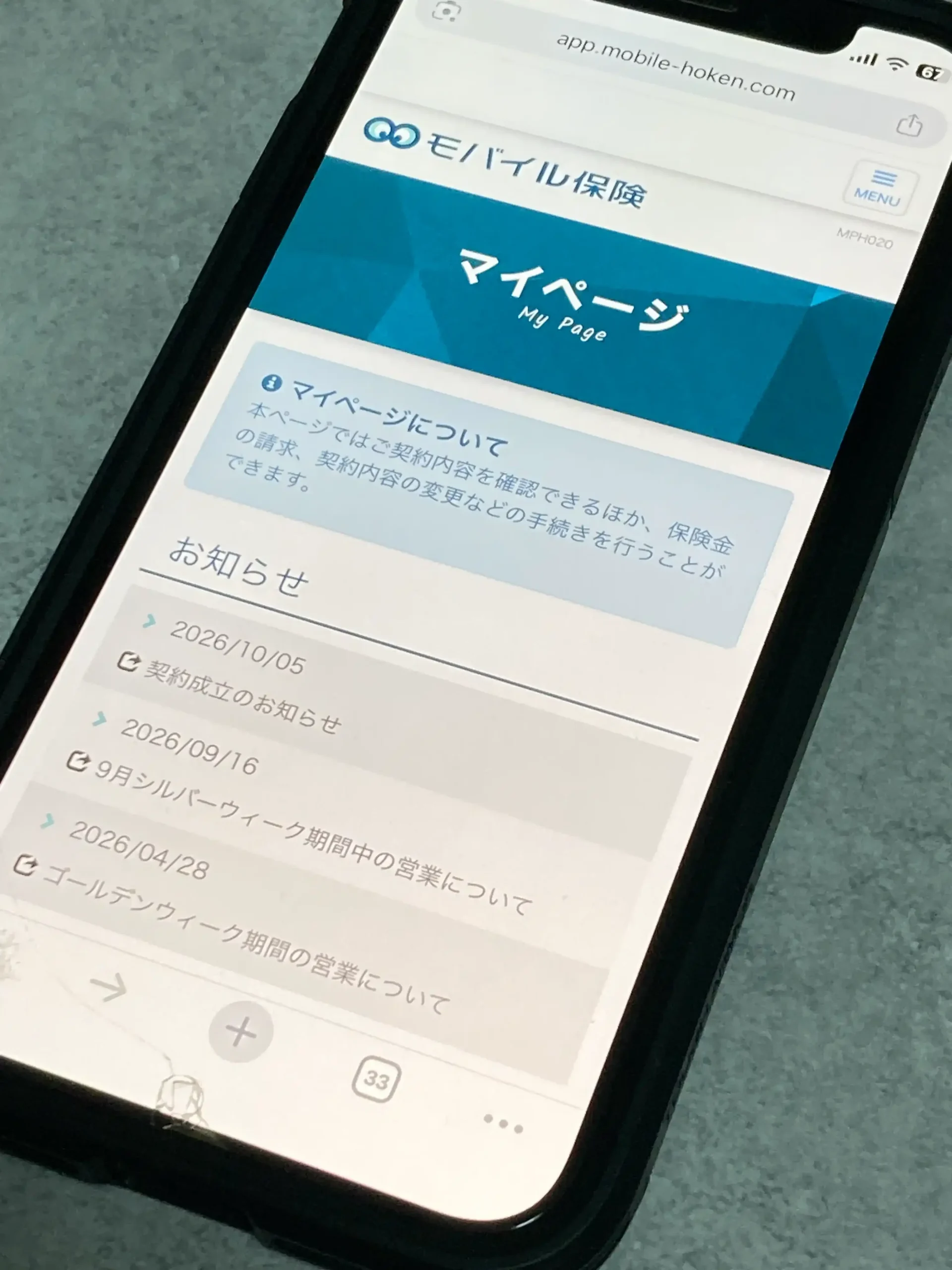 モバイル保険のマイページのトップ画面。お知らせ欄に契約成立のお知らせが出ている様子をスマホで撮影した写真